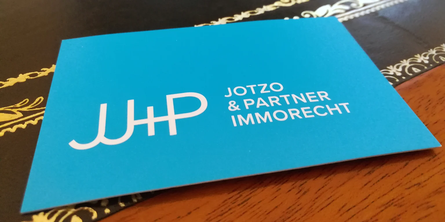 Blaue JJ+P-Kanzleikarte auf einem Tisch
